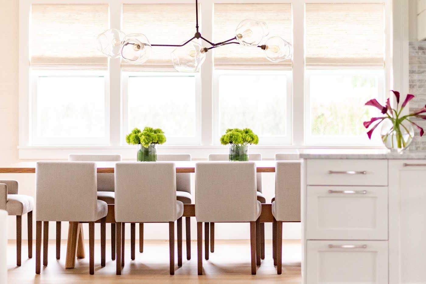 Kitchen table with greenery on top and wall of windows