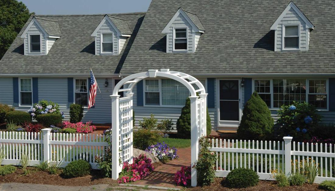 Perfection Fence’s Mt. Vernon Line of ForeverVinyl fencing and elliptical Grand Arbor with English Lattice side panels & keystone adornment beautifully enhance the look of this traditional 角 Cod style home.