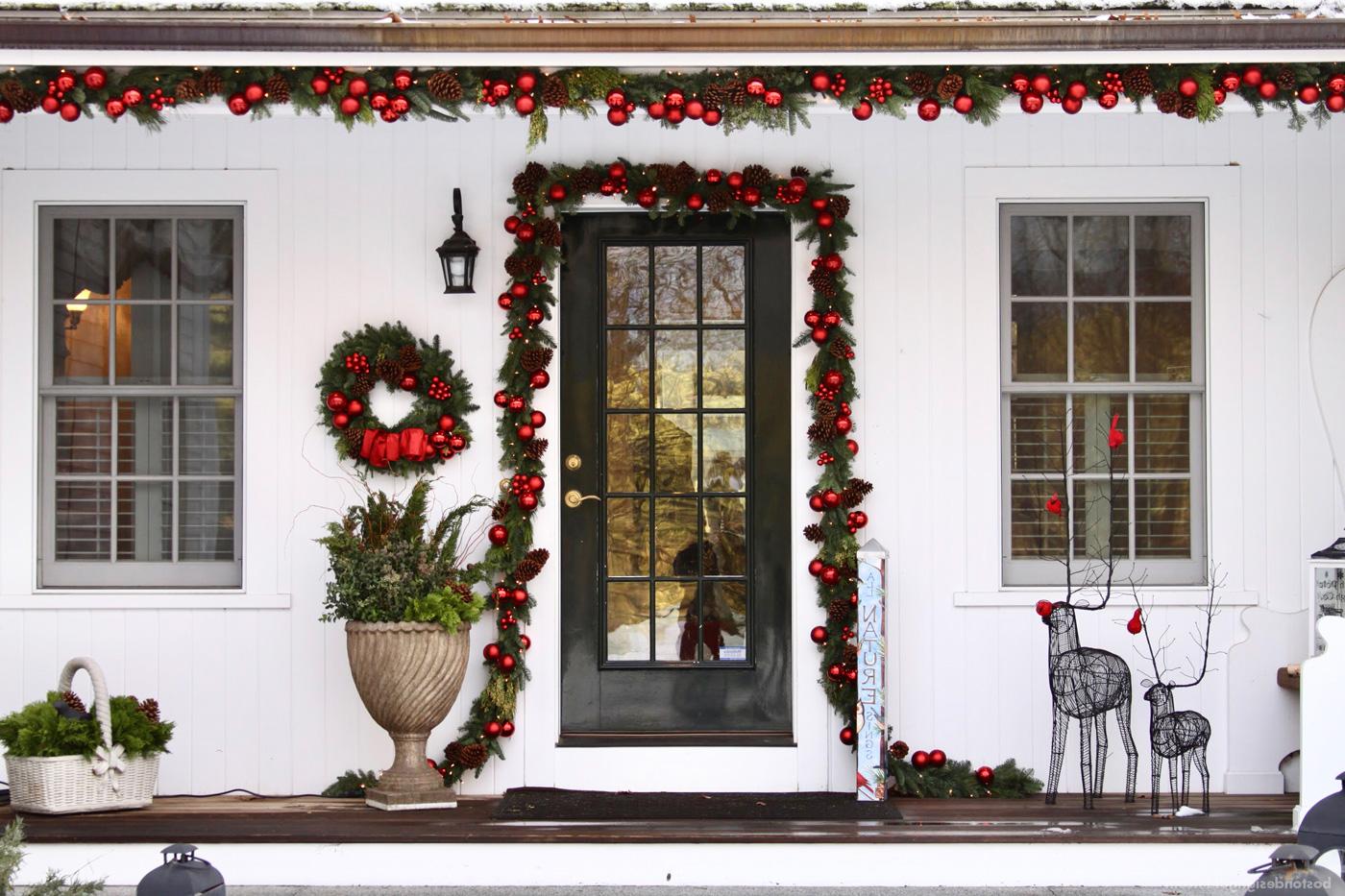 New England home in red holiday decorations by 花坛花园服务